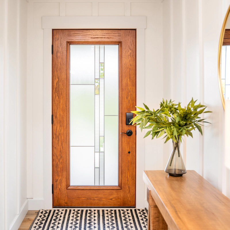 a newly installed wooden door with mosaic glass accent